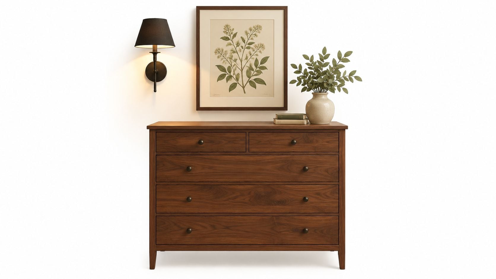 A wooden dresser with a wall sconce, framed botanical print, and a potted plant on top.